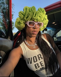 a woman wearing a green crocheted hat in a car