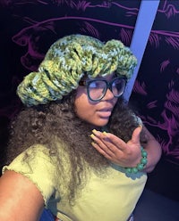 a woman wearing glasses and a green hat