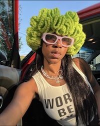 a woman wearing a green crochet hat in a car