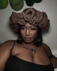 a black woman wearing a crocheted hat