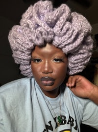 a black woman wearing a purple afro wig