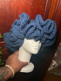 a mannequin wearing a blue ruffled hat