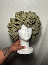 a mannequin wearing a green crocheted hat
