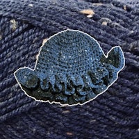 a crocheted hat on top of a ball of yarn